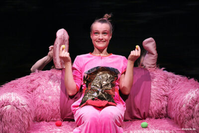 Luise Audersch sitzt auf einem rosanen Sofa.
